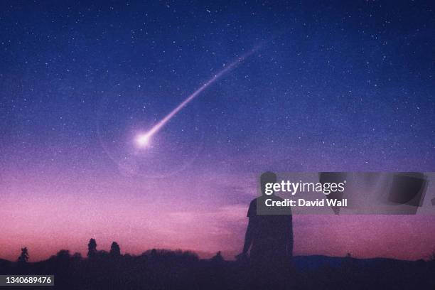 a man silhouetted against the night sky. looking at a shooting star. with an artistic, textured edit. - comet stock-fotos und bilder