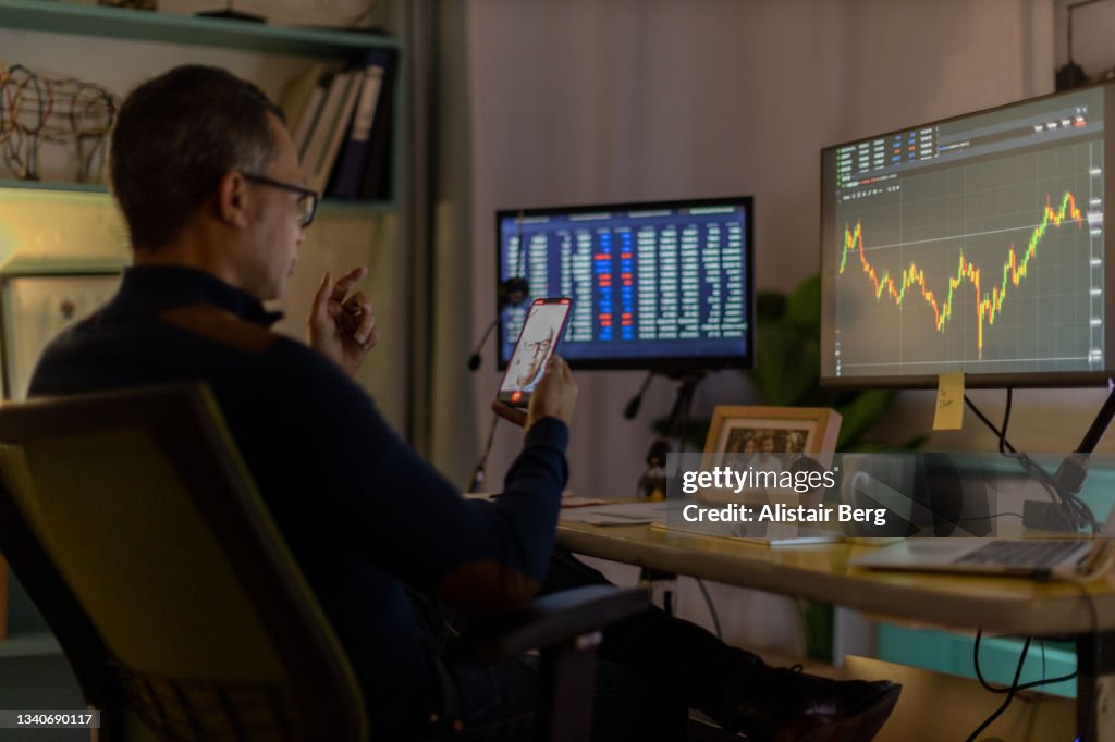 Currency trader on video call from his home office
