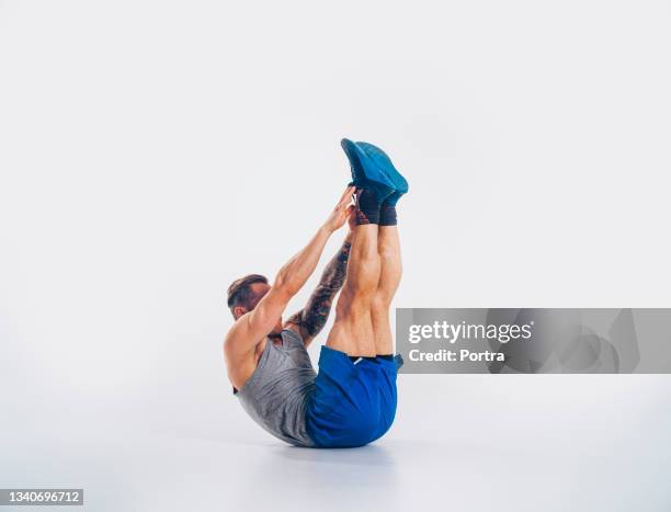 muscular man doing abdominal workout - toe touch stock pictures, royalty-free photos & images