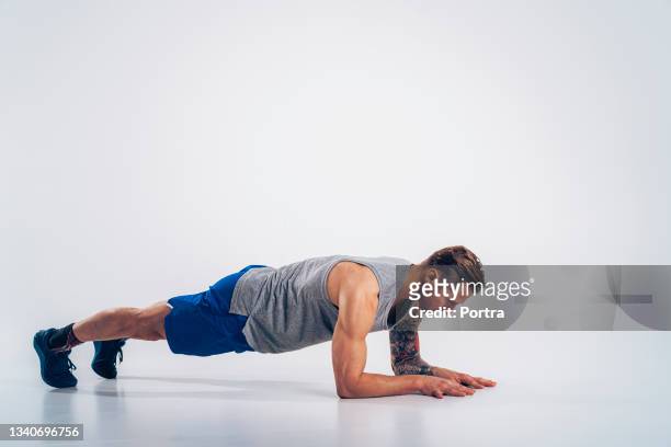 fitness man doing plank exercise - human arm stock pictures, royalty-free photos & images