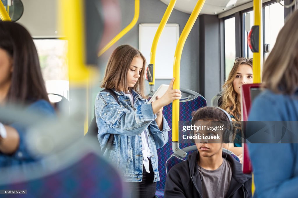 Girl using smart phone in bus