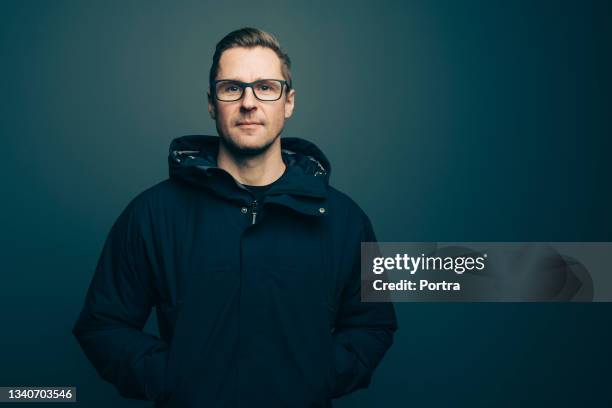 adult male wearing winter coat staring into camera - blonde man stockfoto's en -beelden