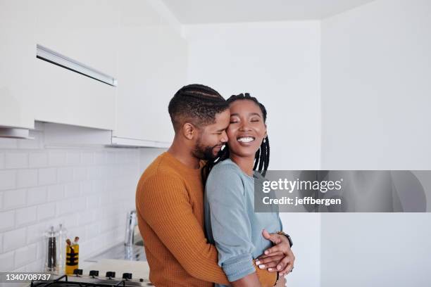 shot of a young couple being affectionate in the kitchen together at home - leaning stock pictures, royalty-free photos & images