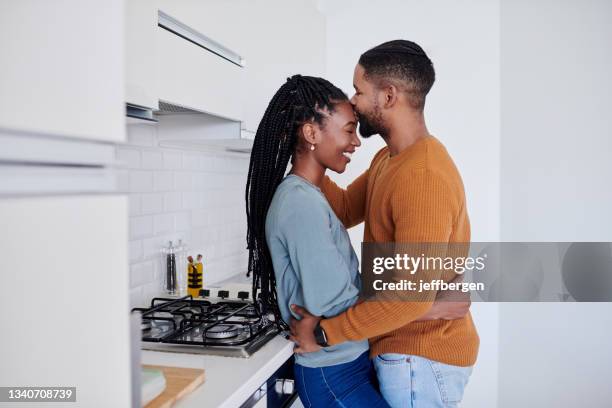 tiro de um jovem casal sendo carinhoso na cozinha juntos em casa - forehead - fotografias e filmes do acervo