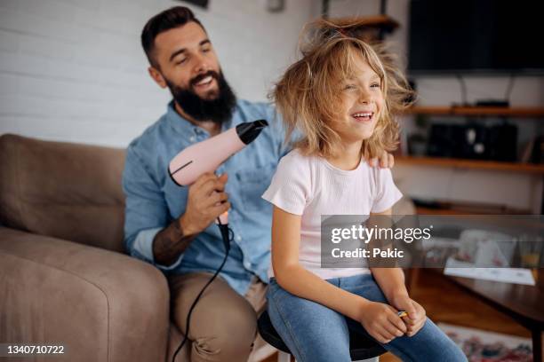 father drying his cute little daughter's hair with blowdryer - secar o cabelo com secador imagens e fotografias de stock
