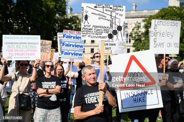 Supporters of leasehold reform campaign groups hold placards as they protest outside the Houses of Parliament, in Parliament Square on September 16,...