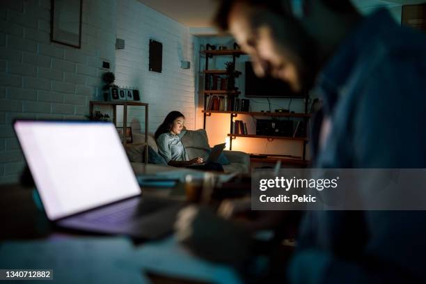 couple working late from their apartment - telecommuting couple stock pictures, royalty-free photos & images
