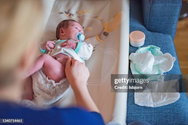 mother changing diaper to her newborn baby. - baby wipes stock pictures, royalty-free photos & images