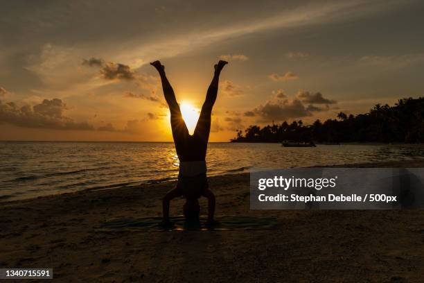 silhouette of man doing handstand at beach against sky during sunset,bora bora,french polynesia - self-discipline stock pictures, royalty-free photos & images
