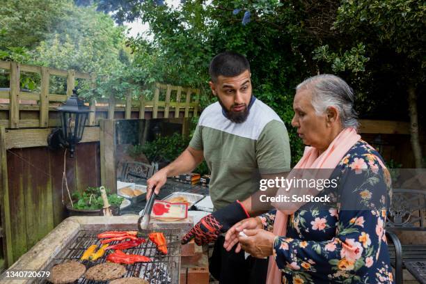 cooking on the bbq together - family barbeque garden stock pictures, royalty-free photos & images