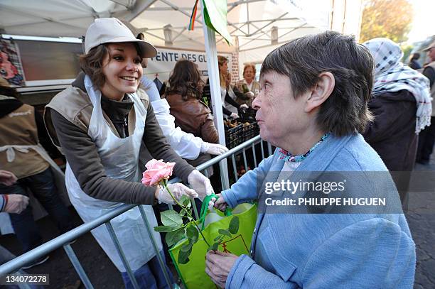 Une bénévole de l'association "La Tente des Glâneurs" distribue gratuitement un sac de fruits et légumes invendus à une femme, le 20 novembre 2011 à...