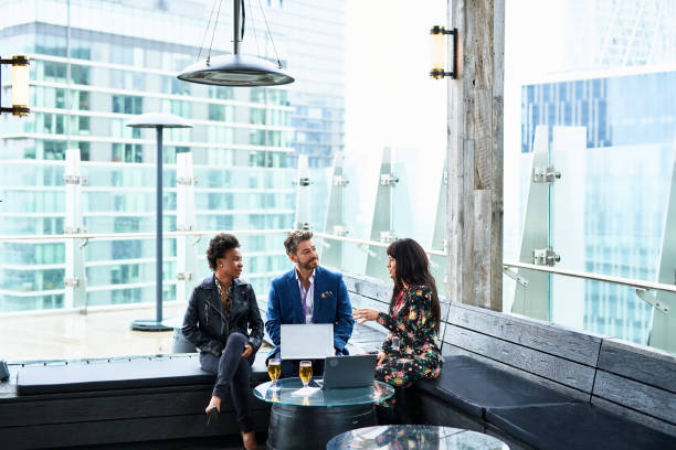 three multi racial business colleagues chatting at businesses conference - business attachments stock pictures, royalty-free photos & images