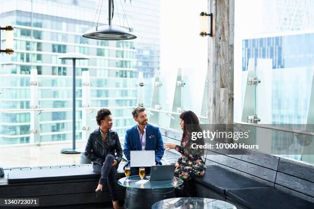 three multi racial business colleagues chatting at businesses conference - business team international stock pictures, royalty-free photos & images