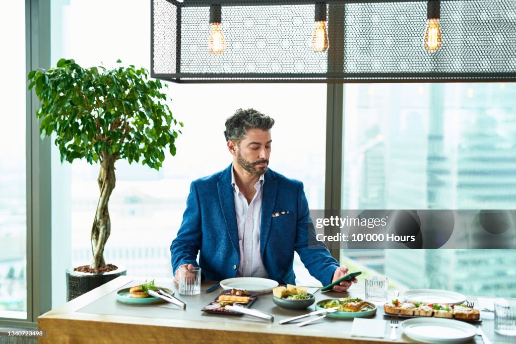 Mature man using phone over conference lunch
