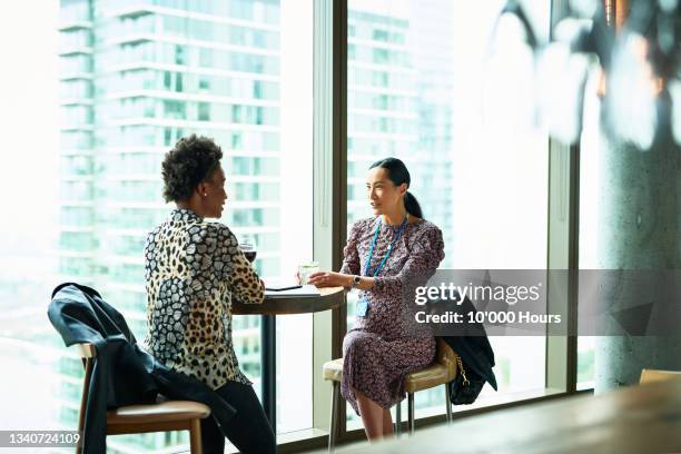 two women talking at business conference - head on table stock pictures, royalty-free photos & images