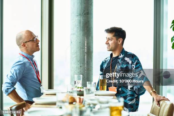 two men having conversation during conference lunch - lanyard stock pictures, royalty-free photos & images