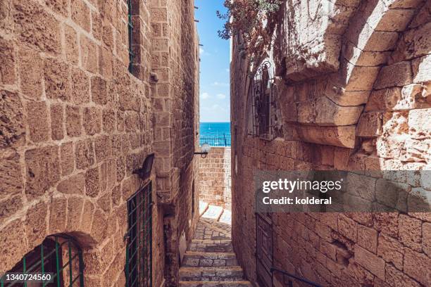 historic neighborhood with narrow view of mediterranean sea - tel aviv stock pictures, royalty-free photos & images