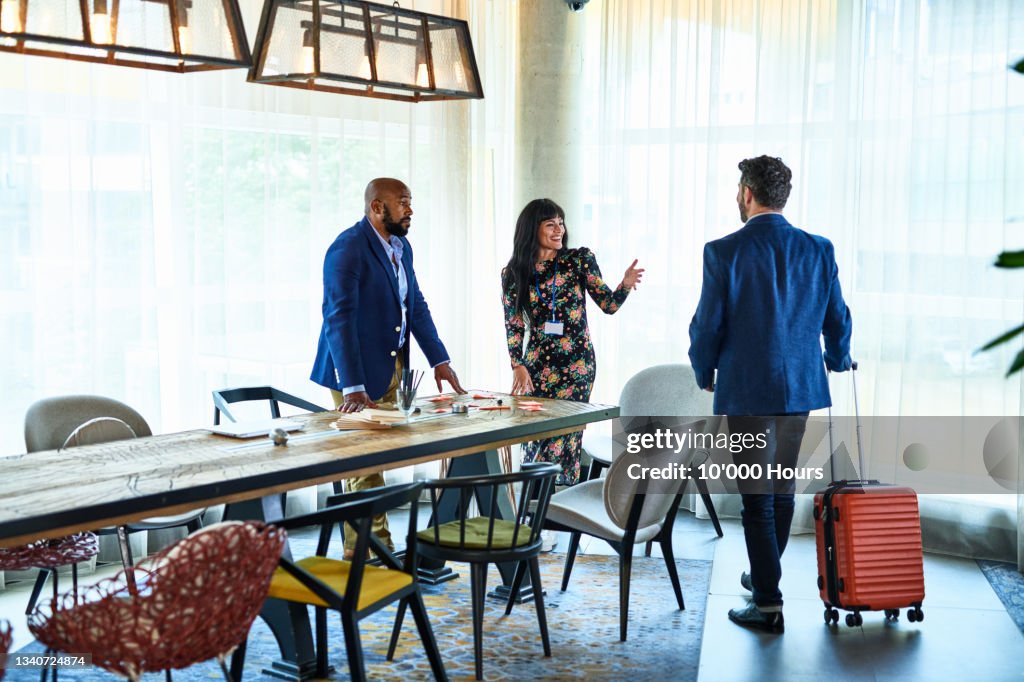 Businessman arriving at international business event with wheeled suitcase