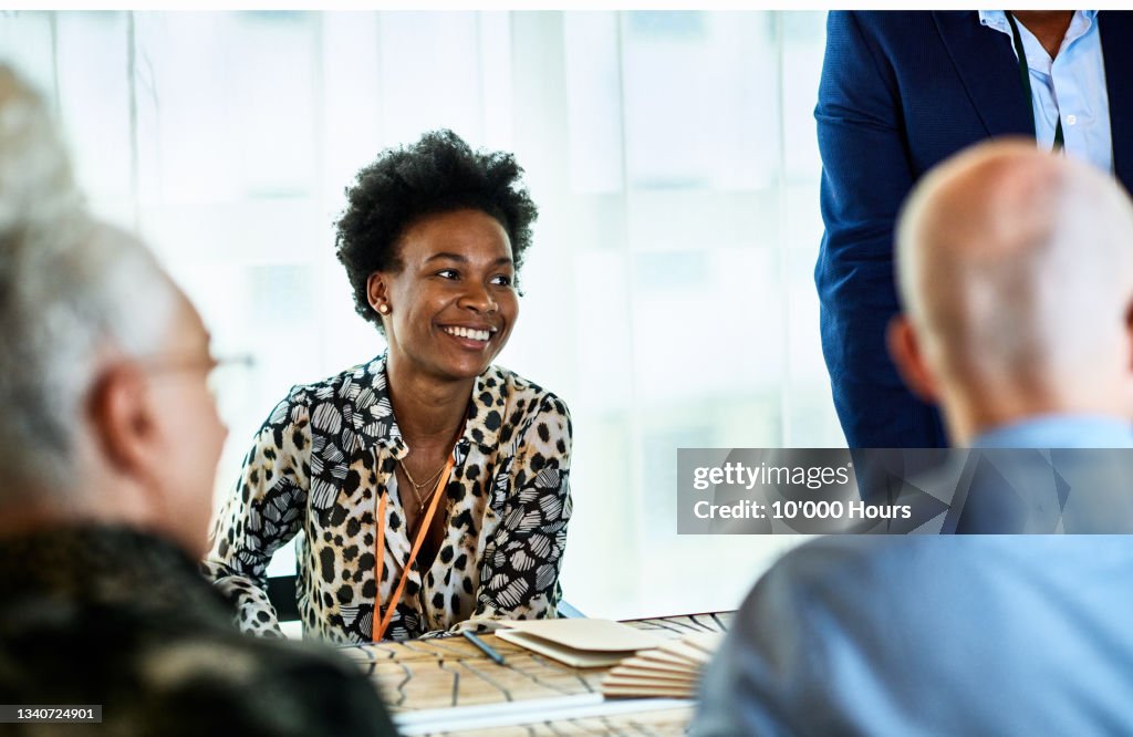 Candid portrait of mid adult black businesswoman smiling in meeting