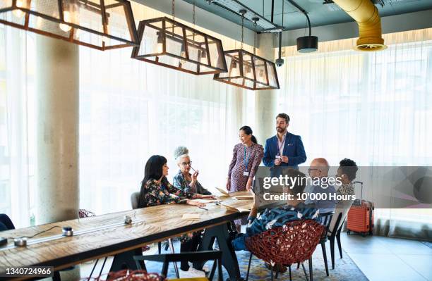 diverse multi racial business colleagues at meeting table - corporate travel photos et images de collection