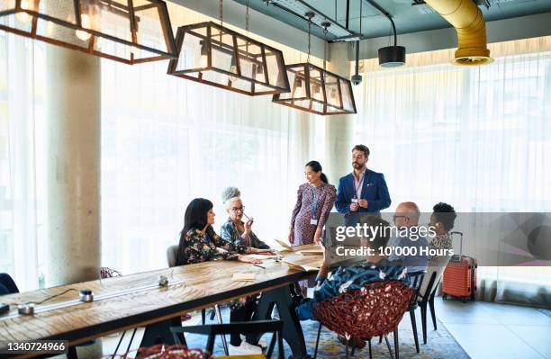 diverse multi racial business colleagues at meeting table - business team stockfoto's en -beelden