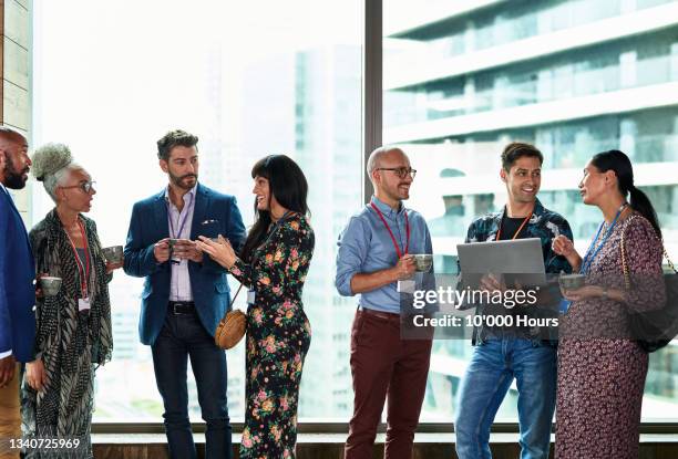 multi racial business people at meet and greet in conference - congrès photos et images de collection