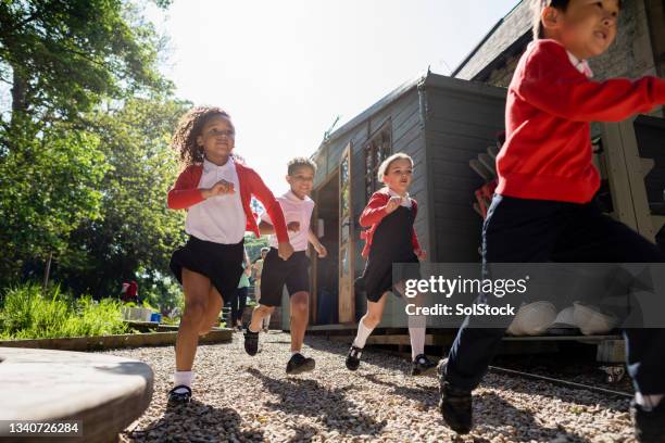 corriendo juntos al patio de la escuela - britain playgrounds fotografías e imágenes de stock