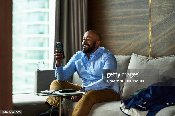 mature black businessman calling kids on video call - guy on phone stock-fotos und bilder