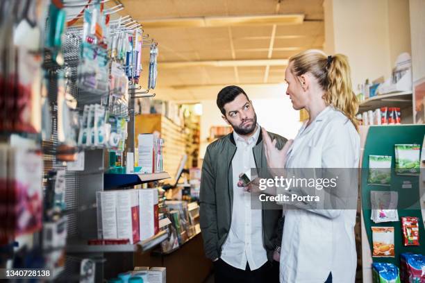 pharmacist explaining medicine to customer - pharmacy customer stock pictures, royalty-free photos & images