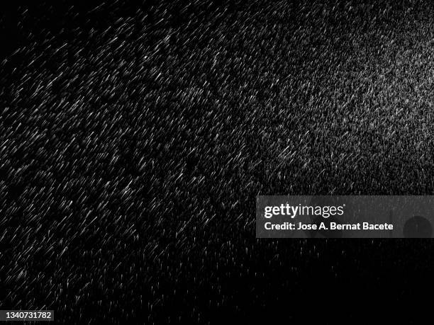 sprayed water drops floating on a black background. - rainy day stockfoto's en -beelden