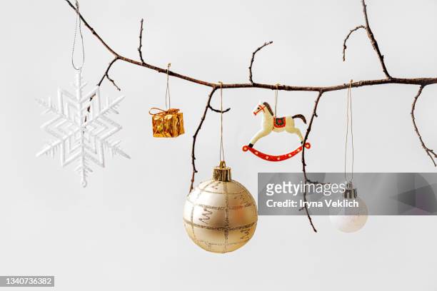natural zero waste decoration idea for christmas. tree branch decorated with balls,  gift box and snowflake on gray background. - christmas tree branch stock pictures, royalty-free photos & images
