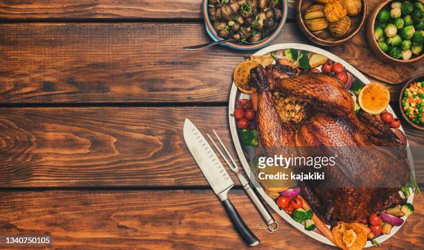dîner traditionnel à la dinde farcie avec des plats d’accompagnement pour la célébration de thanksgiving - dinde rôtie photos et images de collection