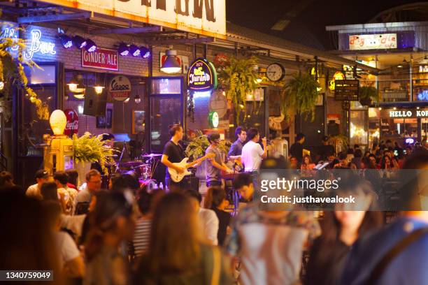 crowded bar and thai music band on night market esplanade - busy bar stock pictures, royalty-free photos & images