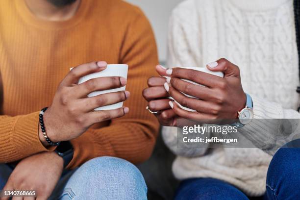 primer plano de una pareja irreconocible tomando café mientras se relajan juntos en casa - couple holding hands fotografías e imágenes de stock