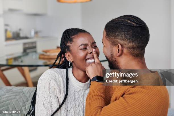 shot of an affectionate young couple relaxing together at home - teasing stock pictures, royalty-free photos & images