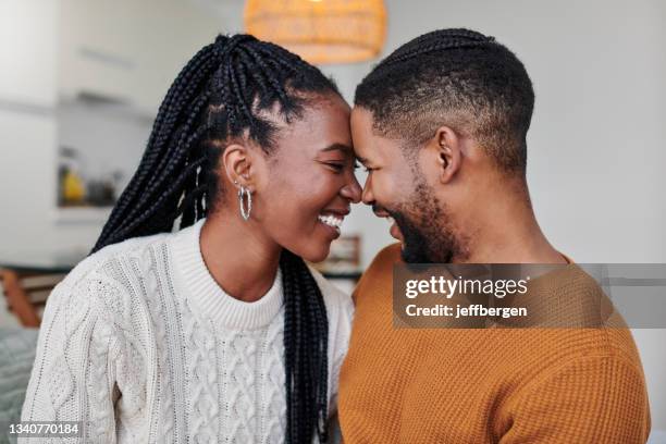 shot of an affectionate young couple relaxing together at home - rubbing noses stock pictures, royalty-free photos & images