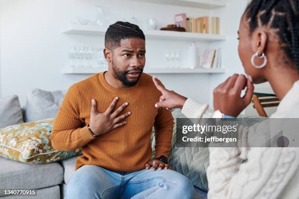 shot of a young couple having an argument at home - in a row stockfoto's en -beelden