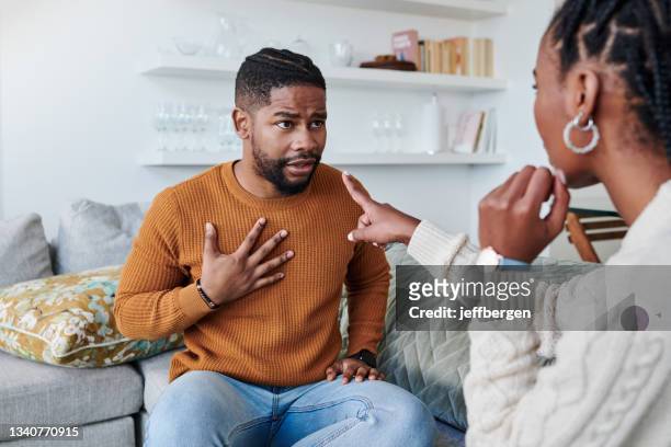 shot of a young couple having an argument at home - angry black woman stock pictures, royalty-free photos & images