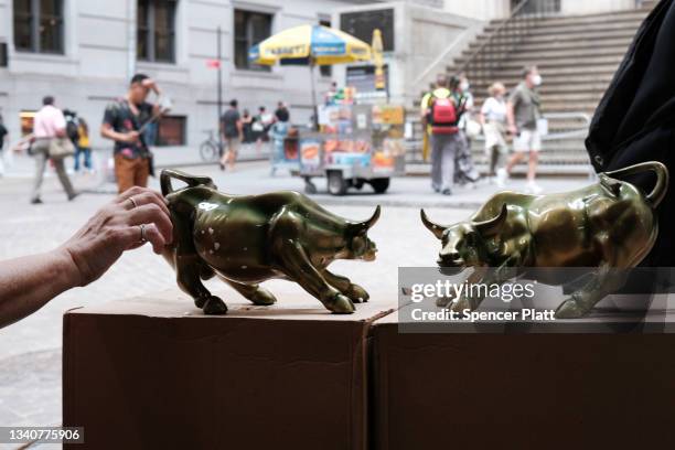 Vendor sells replicas of the Wall Street Bull outside of the New York Stock Exchange on September 16, 2021 in New York City. Despite a rise in retail...
