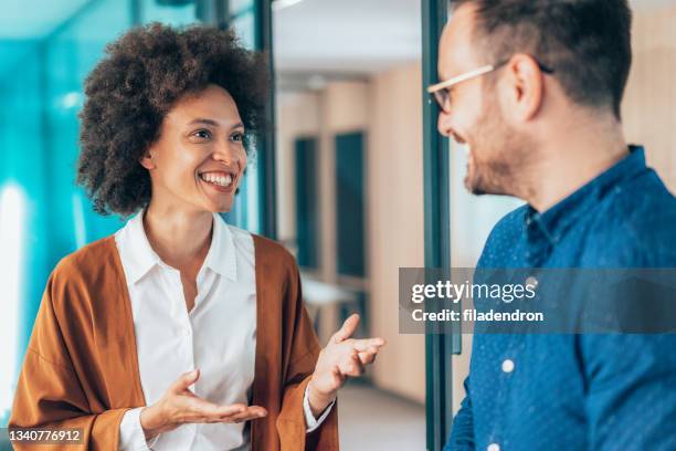 zwei geschäftsleute unterhalten sich im büro - cool modern mann büro business stock-fotos und bilder