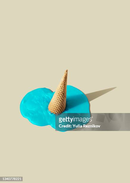 melting blue ice cream waffle on the beige background - sadness concept stock pictures, royalty-free photos & images