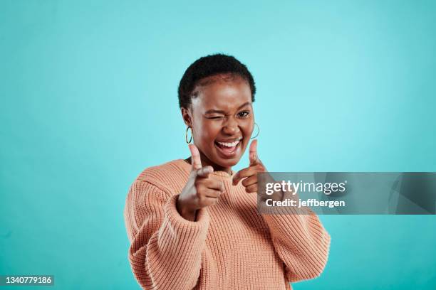 shot of a beautiful young woman posing against a turquoise background - winking stock pictures, royalty-free photos & images