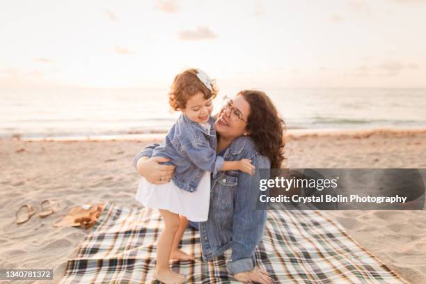 eine 30-jährige mutter und eine 2-jährige tochter genießen einen ruhigen golden beach sonnenaufgang in palm beach, florida im september 2021 - 30 year old female stock-fotos und bilder