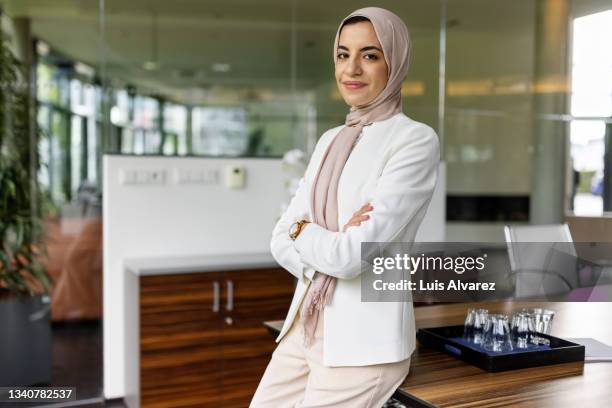 portrait of a mulsim businesswoman with headscarf in modern office - hijab stock pictures, royalty-free photos & images