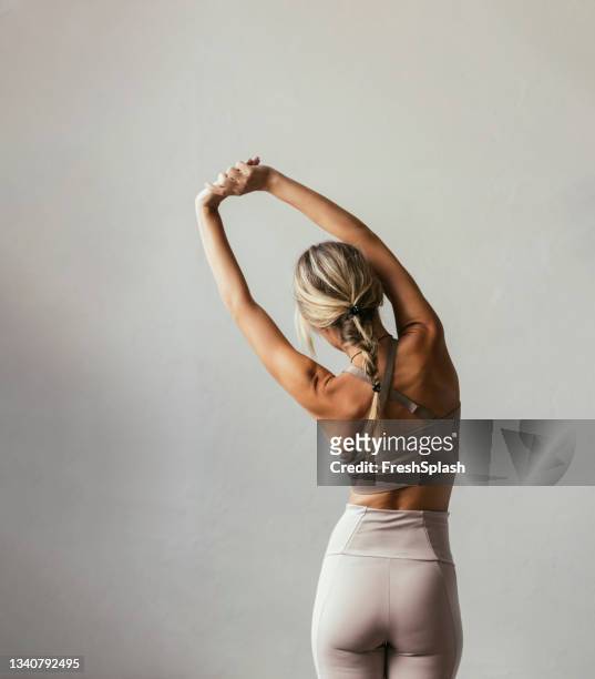 una giovane donna caucasica bionda che si allunga - ginnastica foto e immagini stock