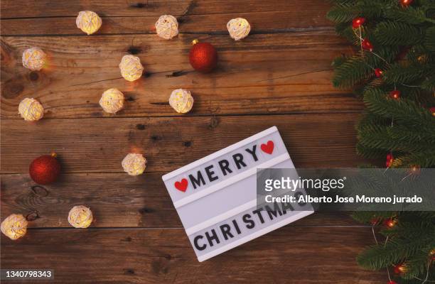 merry christmas in lightbox on wood background - símbolo stock pictures, royalty-free photos & images