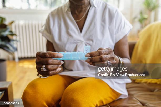 woman taking daily dosage of medicines - pillerförpackning bildbanksfoton och bilder