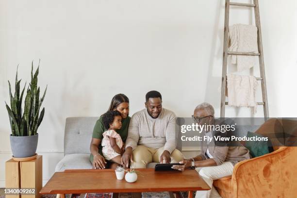 financial advisor explaining paperwork to young mixed race couple with toddler daughter - mum sitting down with baby stockfoto's en -beelden