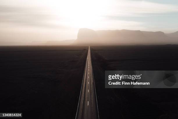 interminable camino recto hacia el sol en islandia - cultura islandesa fotografías e imágenes de stock