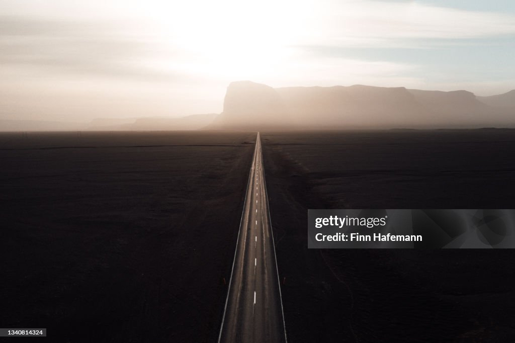 Endless straight road into the sun on Iceland